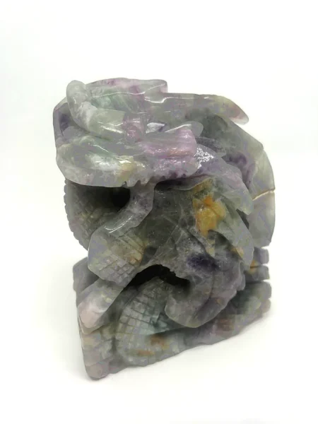 Side view of hand-carved Rainbow Fluorite dragon sculpture showing detailed head wings and scales